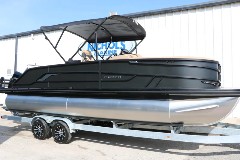 The Image of 2026 Evotti 723CS pontoon boat on trailer, black exterior, under sunny sky. - 0