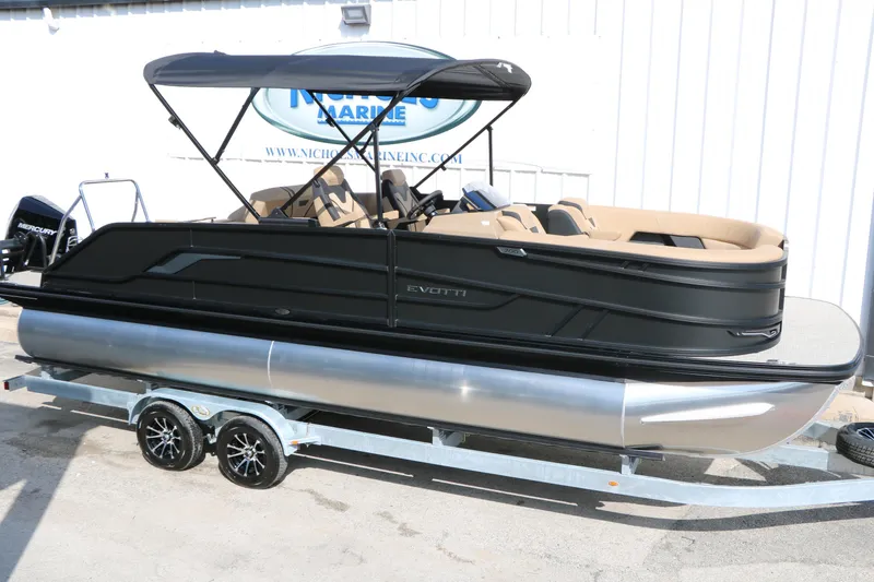 Slide: The Image of 2026 Evotti 723CS pontoon boat on trailer, black exterior, beige interior, under canopy. - 14