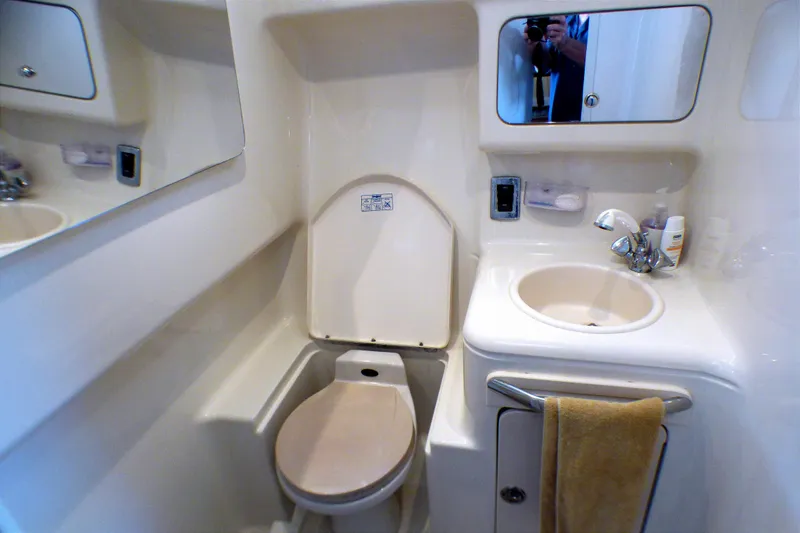 Slide: The Image of 2002 Sea Ray 340 Amberjack bathroom with toilet, sink, and mirror. - 10