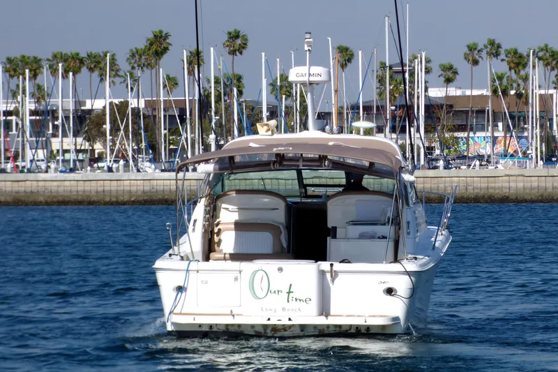 Slide: The Image of 2002 Sea Ray 340 Amberjack boat cruising near marina with palm trees in background. - 2