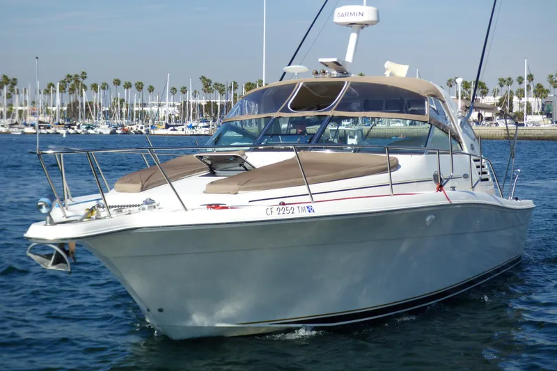 Slide: The Image of 2002 Sea Ray 340 Amberjack boat on water, marina background, clear sky. - 3