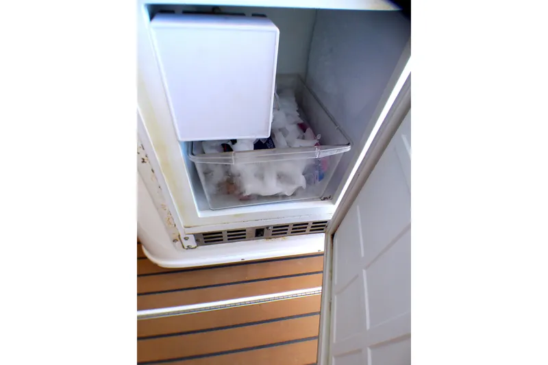 Slide: The Image of Freezer compartment on 2002 Sea Ray 340 Amberjack boat, containing ice and items. - 42