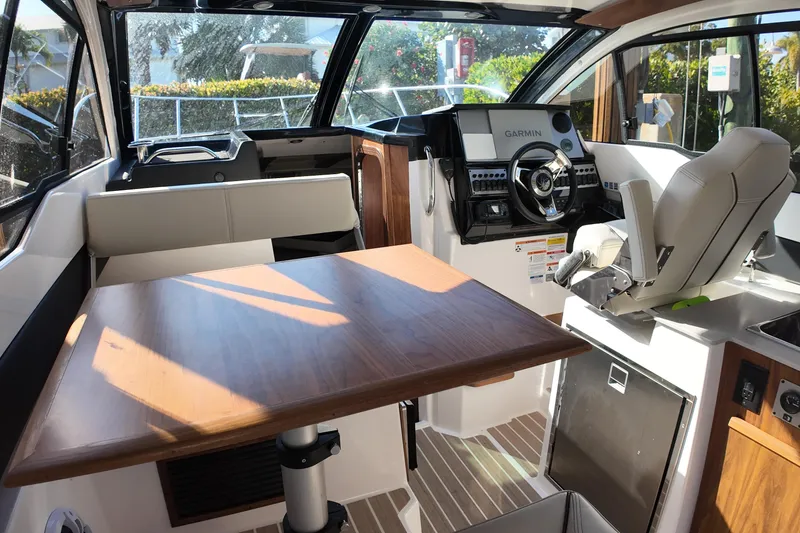 Slide: The Image of Interior of 2026 Solara S-250 Coupe boat with modern helm and wooden table. - 11