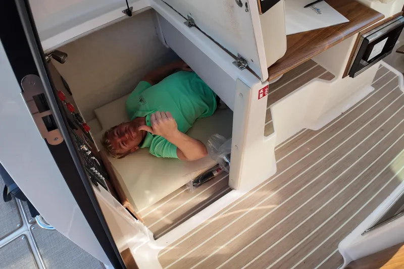 Slide: The Image of Person lying in compact cabin space of 2026 Solara S-250 Coupe boat. - 18