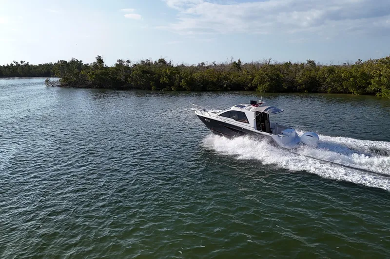 Slide: The Image of 2026 Solara S-250 Coupe cruising on a scenic waterway with lush greenery. - 21