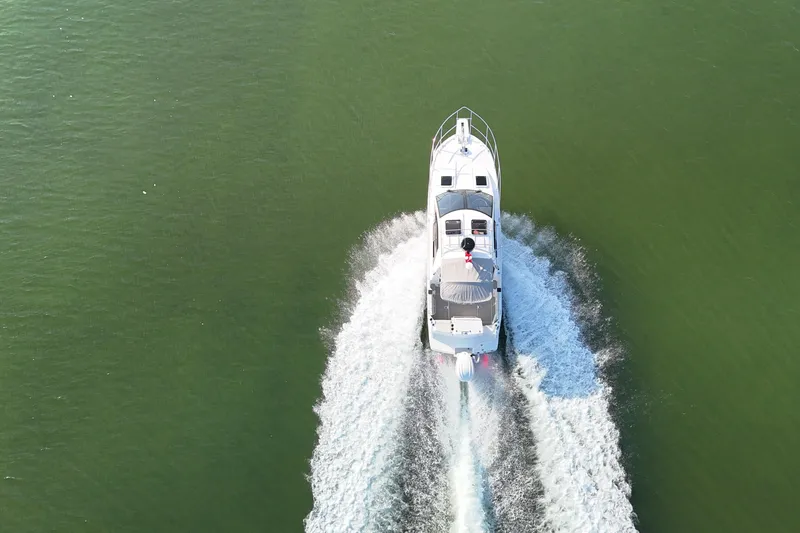Slide: The Image of Aerial view of 2026 Solara S-250 Coupe boat cruising on green water. - 4