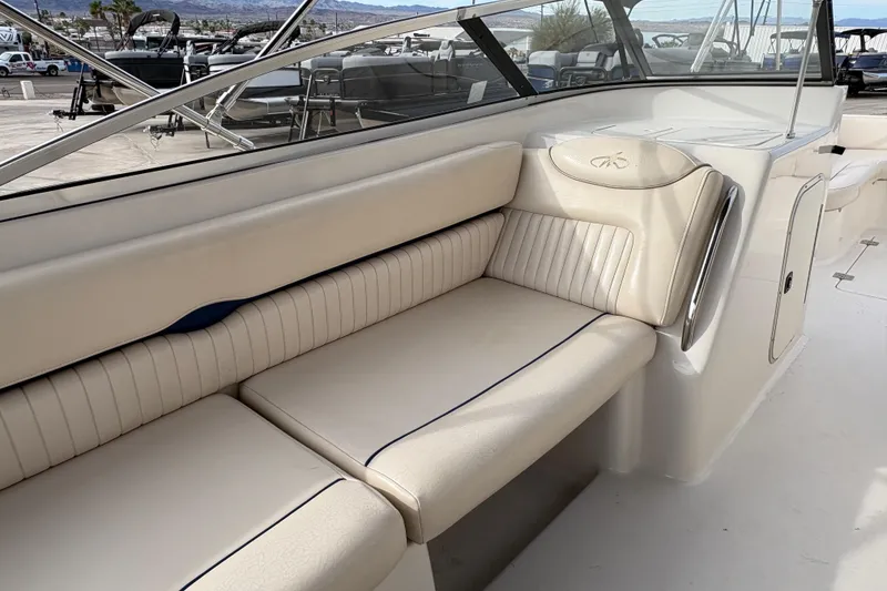 Slide: The Image of 2002 Monterey 240 Explorer Sport boat interior with beige seating and sleek design. - 8