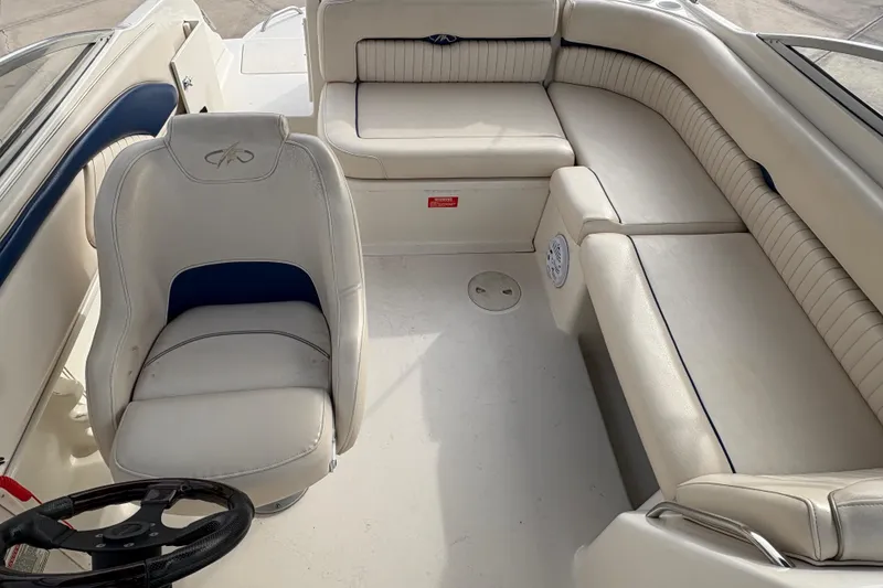 Slide: The Image of 2002 Monterey 240 Explorer Sport boat interior with white seating and steering wheel. - 9