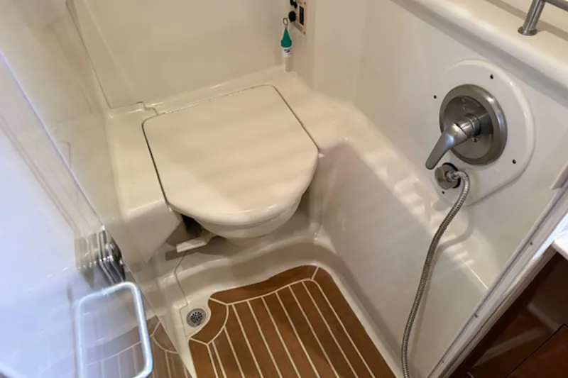 Slide: The Image of 2011 Sea Ray Sundancer 370 bathroom with shower and toilet, featuring wood-patterned flooring. - 19