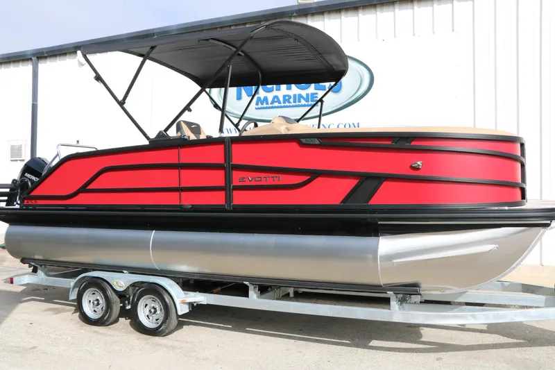 The Image of Red 2026 Evotti 521CS pontoon boat on trailer, parked outside a marine dealership. - 0