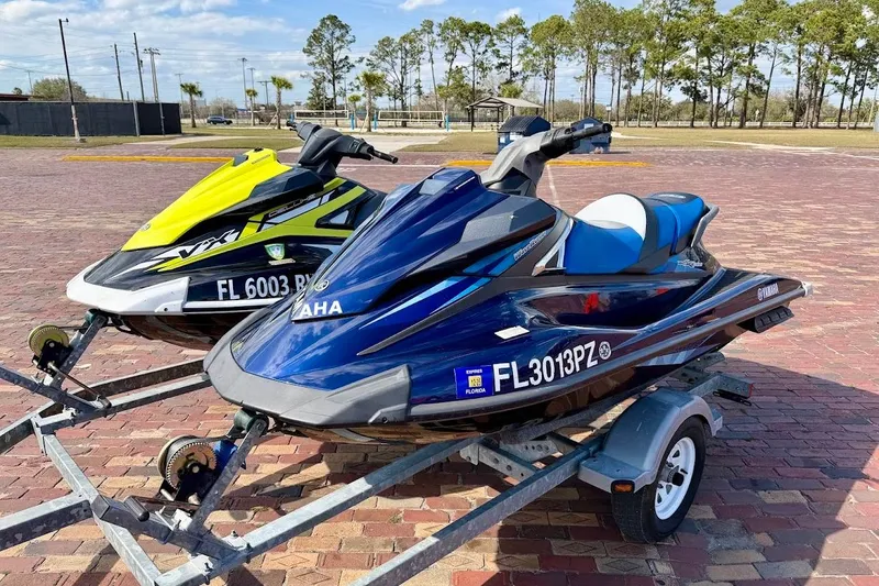 Slide: The Image of 2019 Yamaha WaveRunner VX Deluxe jet skis on trailers, parked on brick pavement. - 4