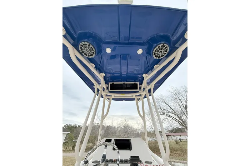 Slide: The Image of 2024 Carolina Skiff 24 Ultra Elite boat with blue T-top and speakers. - 11