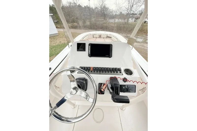 Slide: The Image of 2024 Carolina Skiff 24 Ultra Elite boat dashboard with steering wheel and navigation controls. - 13