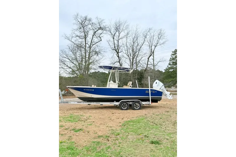 Slide: The Image of 2024 Carolina Skiff 24 Ultra Elite boat on trailer, blue hull, parked outdoors. - 3