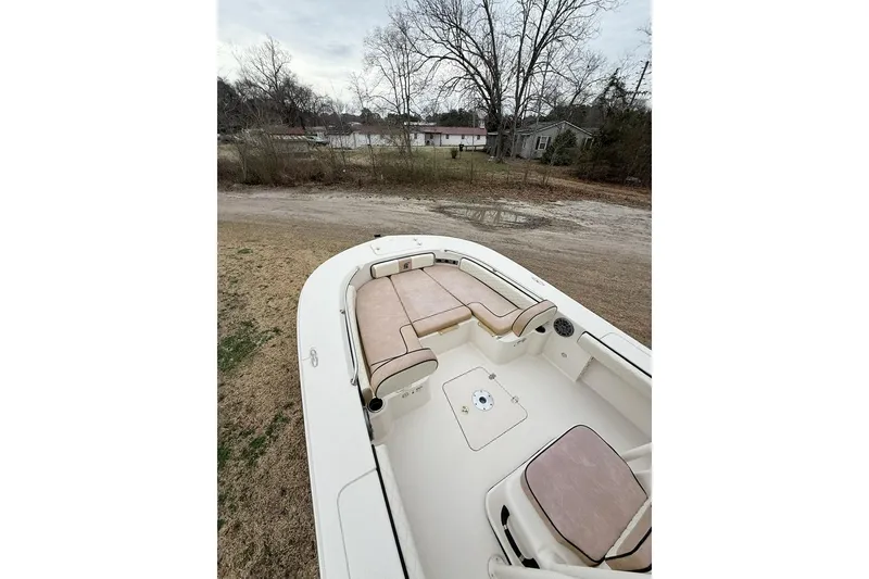 Slide: The Image of 2024 Carolina Skiff 24 Ultra Elite boat with beige seating, parked on grass. - 7