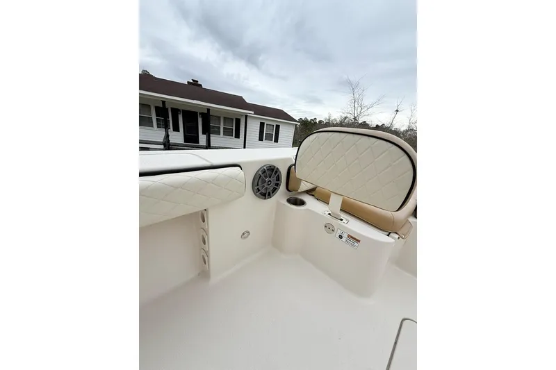 Slide: The Image of 2024 Carolina Skiff 24 Ultra Elite boat interior with cushioned seating and speaker. - 8