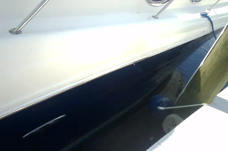 Slide: The Image of 2005 Sea Ray 300 Sundancer boat side view with railing and water reflection. - 1