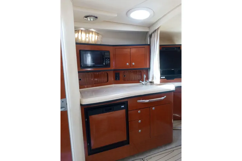 Slide: The Image of Interior of 2005 Sea Ray 300 Sundancer yacht with kitchenette and modern amenities. - 10