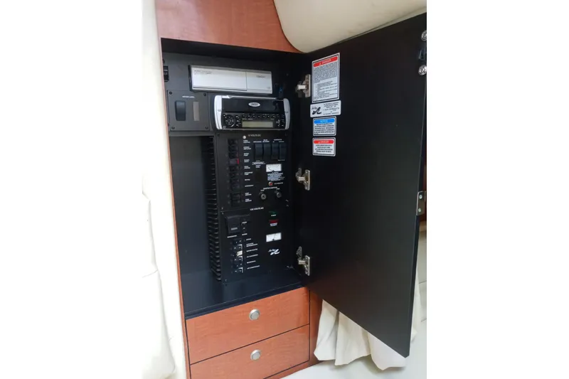 Slide: The Image of Electrical panel inside 2005 Sea Ray 300 Sundancer boat, featuring control switches and stereo system. - 14