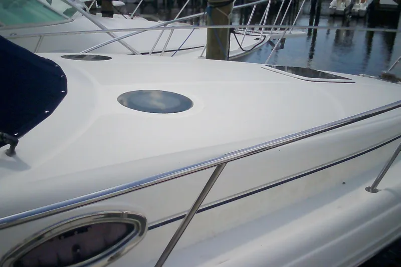 Slide: The Image of 2005 Sea Ray 300 Sundancer yacht deck with sleek design and porthole. - 2