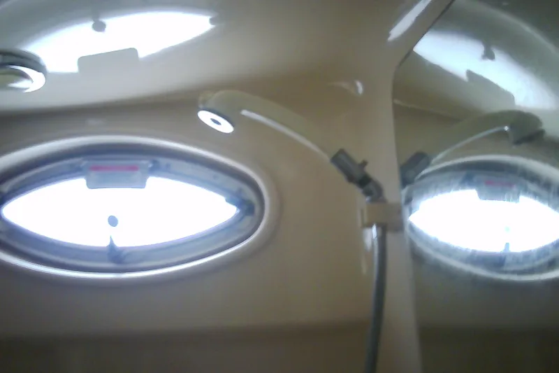 Slide: The Image of Interior of 2005 Sea Ray 300 Sundancer boat with oval windows and lighting. - 29