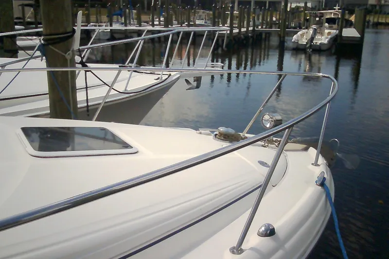 Slide: The Image of 2005 Sea Ray 300 Sundancer docked at marina, showcasing sleek design and polished railings. - 3