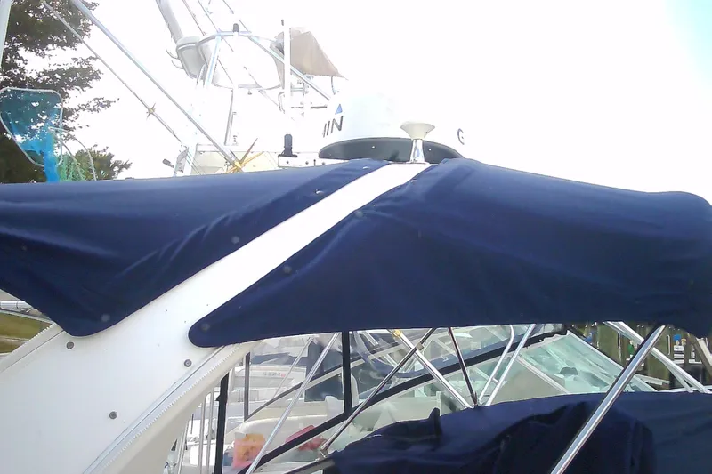 Slide: The Image of 2005 Sea Ray 300 Sundancer with blue canvas cover and radar equipment. - 4