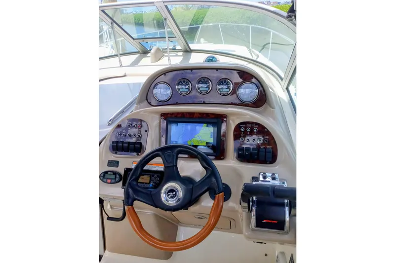 Slide: The Image of 2005 Sea Ray 300 Sundancer helm with gauges, steering wheel, and navigation display. - 6