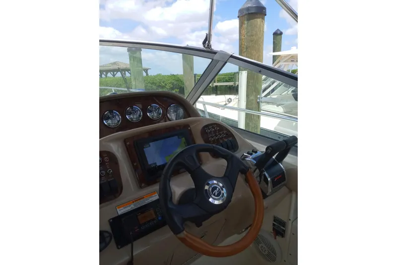 Slide: The Image of 2005 Sea Ray 300 Sundancer helm with steering wheel and navigation controls. - 7