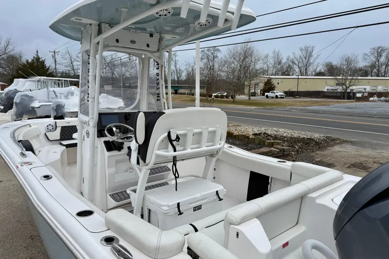 Slide: The Image of 2023 Tidewater 220 LXF boat with T-top and modern helm, parked outdoors. - 12