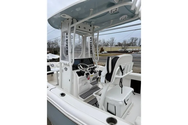 Slide: The Image of 2023 Tidewater 220 LXF boat interior with helm, seating, and T-top. - 15