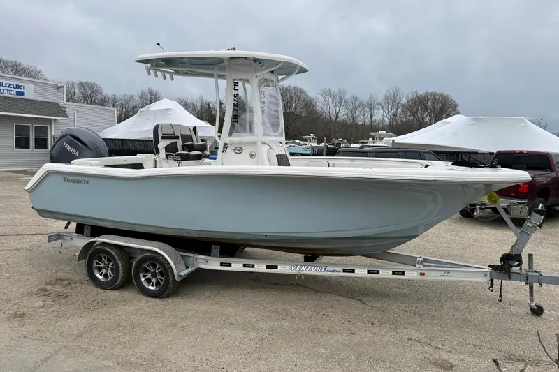 Slide: The Image of 2023 Tidewater 220 LXF boat on trailer, parked outdoors near marine dealership. - 3