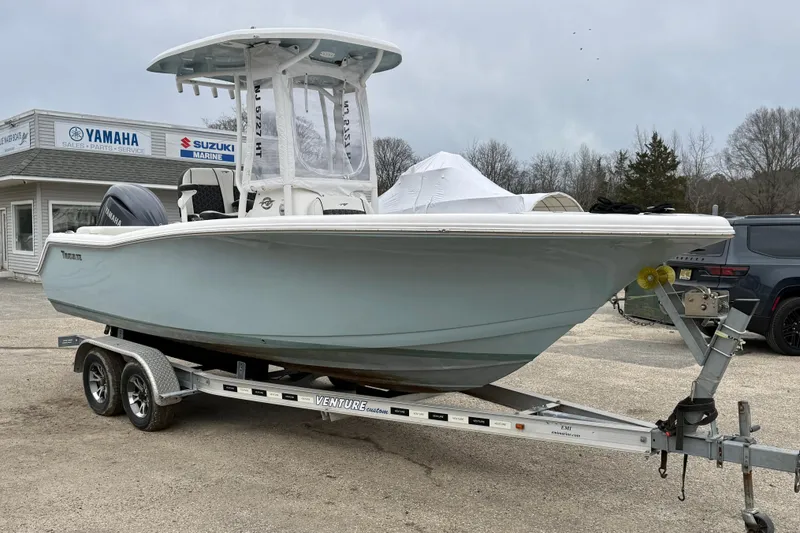 Slide: The Image of 2023 Tidewater 220 LXF boat on trailer, parked near Yamaha and Suzuki Marine dealership. - 5