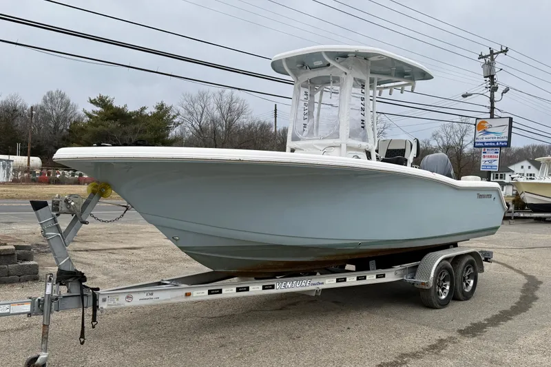 Slide: The Image of 2023 Tidewater 220 LXF boat on trailer, displayed outdoors near dealership. - 7