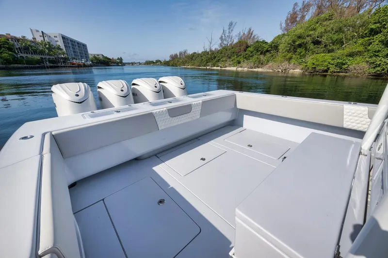 Slide: The Image of 2025 Contender 44 ST boat with quad engines, spacious deck, and scenic waterway view. - 33