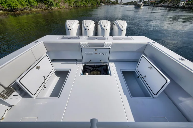 Slide: The Image of 2025 Contender 44 ST boat deck with open storage compartments and quad engines. - 37