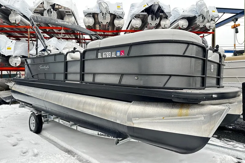 The Image of 2018 Godfrey Sweetwater 2486 C pontoon boat on trailer in snowy storage area. - 0
