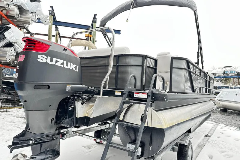 Slide: The Image of 2018 Godfrey Sweetwater 2486 C pontoon boat with Suzuki outboard motor in snowy setting. - 2