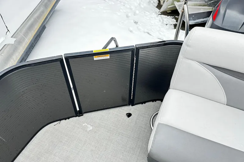Slide: The Image of 2018 Godfrey Sweetwater 2486 C boat interior with gray seating and snow-covered deck. - 11