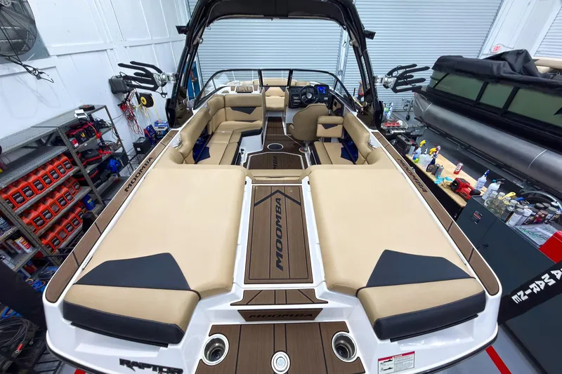 Slide: The Image of 2020 Moomba Kaiyen boat interior with beige seating in a workshop setting. - 12