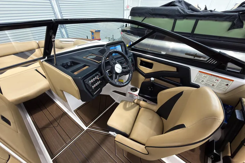 Slide: The Image of 2020 Moomba Kaiyen boat interior with tan seating and modern dashboard controls. - 17