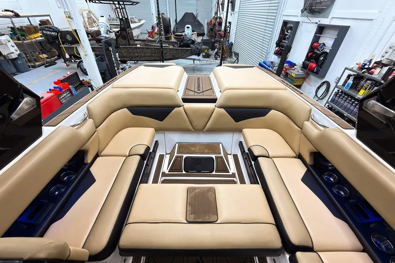 Slide: The Image of 2020 Moomba Kaiyen boat interior with tan seating in a workshop setting. - 26