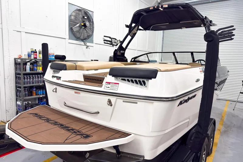 Slide: The Image of 2020 Moomba Kaiyen boat in a garage, showcasing rear deck and seating area. - 3