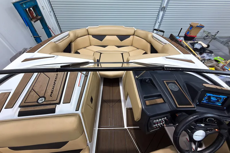 Slide: The Image of 2020 Moomba Kaiyen boat interior with tan seating and modern dashboard controls. - 30