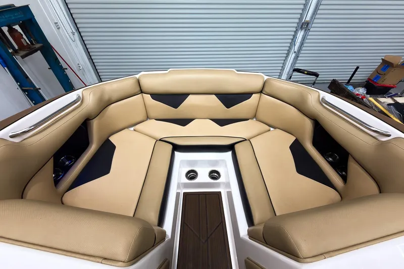 Slide: The Image of 2020 Moomba Kaiyen boat interior with tan and black seating in a garage setting. - 32
