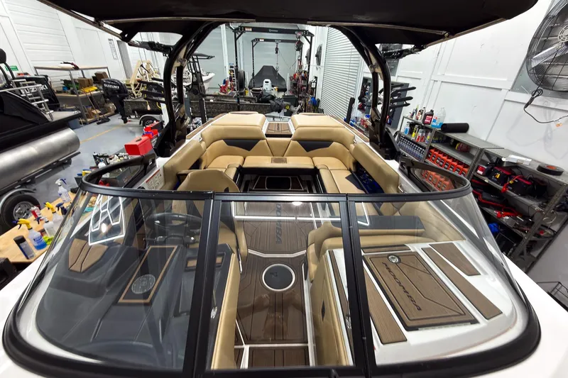 Slide: The Image of 2020 Moomba Kaiyen boat interior in a workshop, featuring tan seating and sleek design. - 33