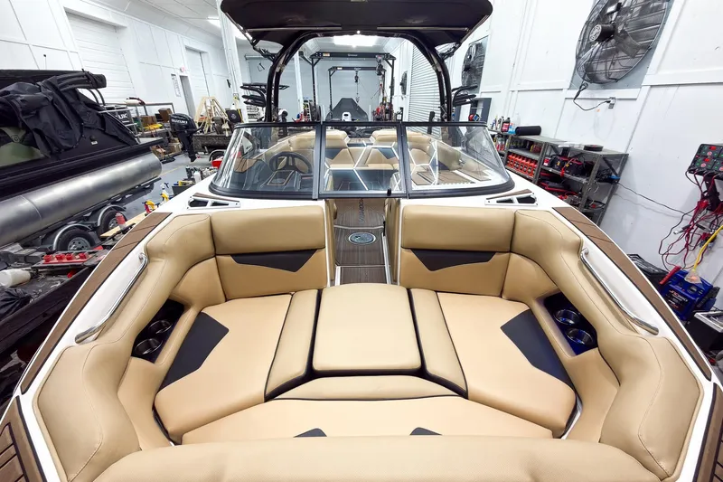 Slide: The Image of 2020 Moomba Kaiyen boat interior with tan seating in a workshop setting. - 8