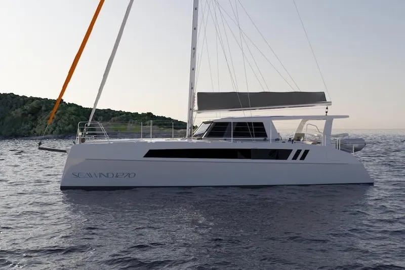 Slide: The Image of 2026 Seawind 1270 catamaran sailing on calm waters near a lush coastline. - 10