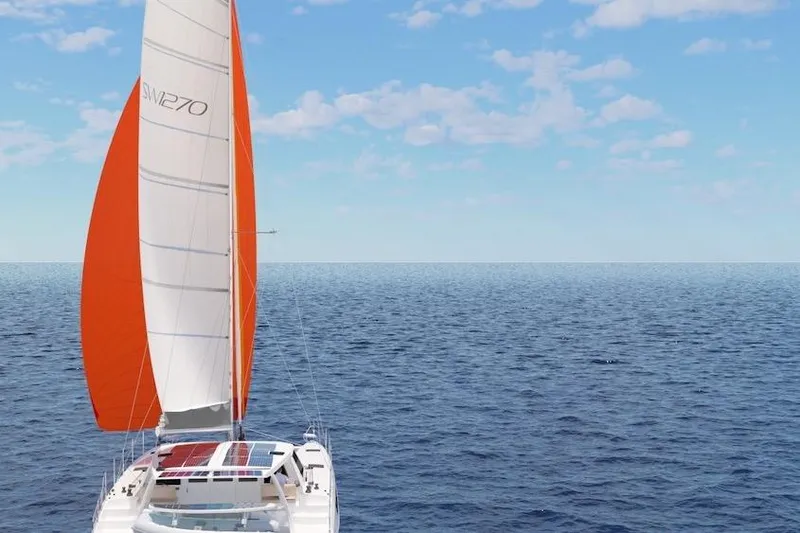 Slide: The Image of 2026 Seawind 1270 catamaran sailing on open ocean with vibrant orange sail. - 2