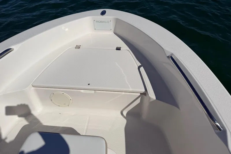 Slide: The Image of 2020 Robalo R160 Center Console boat interior with storage compartment, on calm water. - 15